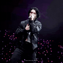 a man is singing into a microphone on stage .