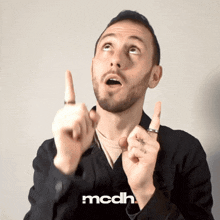 a man in a black jacket with the word mcdh on the bottom left
