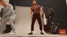 a man in a striped shirt is dancing in front of a subscribe button