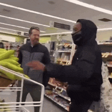 a man in a hooded jacket is standing in a store with another man