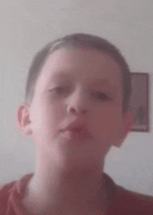 a close up of a young boy 's face with a picture in the background .
