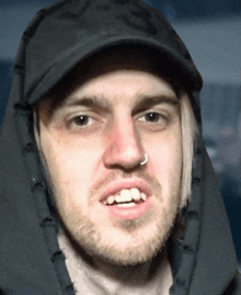 a man with a nose ring is wearing a hooded jacket