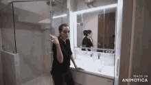 a woman is brushing her teeth in a bathroom next to a mirror .