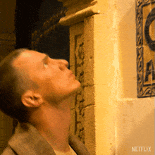 a man looks up at a netflix sign