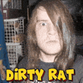 a man with long hair is wearing a shirt that says " dirty rat "
