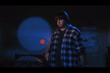 a boy in a plaid shirt is standing in front of a poster that says ' central florida '