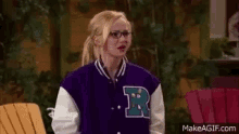a woman wearing a purple and white varsity jacket with the letter r on it .