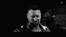 a black and white photo of a bearded man in a leather jacket .