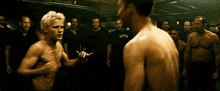 a group of men are standing around a boxing match .