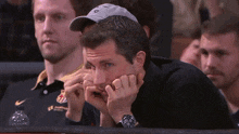 a man with a watch on his wrist is sitting in a crowd