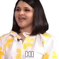 a woman in a yellow and white shirt is smiling and says hi