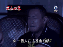 a man sitting in a chair with his eyes closed and chinese writing on the bottom