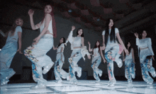 a group of women are dancing on a dance floor and one of their pants says ice cream
