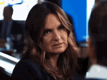 a woman with a serious look on her face looks at a man