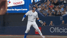 a baseball player for the blue jays is running towards the base