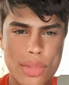 a close up of a young man 's face with a red lip and blue eyes .