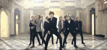 a group of men are dancing in a room with a marble floor .