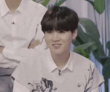 a close up of a person wearing a white shirt and smiling