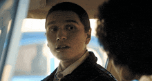 a man in a suit and tie is looking at the camera
