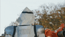 a robot with a hood on is holding a red object