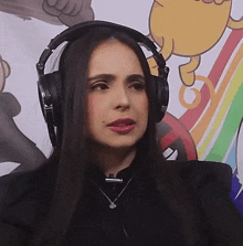 a woman wearing headphones and a necklace looks to the side