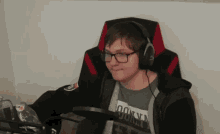 a man wearing headphones is sitting in a chair .