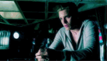 a man is sitting at a table with a gun in his hand .