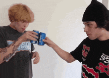 a man holds a can of pepsi next to another man in a black shirt