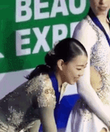 a woman in a white dress is kneeling down next to another woman in a white dress .