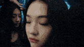 a close up of a woman 's face with her eyes closed in front of a mirror