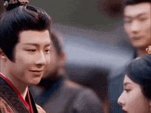 a man with a crown on his head looks at a woman in a red dress