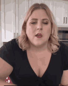 a woman in a black shirt is making a funny face with her mouth open
