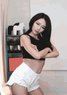 a woman in a black top and white shorts is dancing