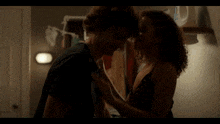 a man and woman kissing in a dark room