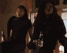 a woman holds a bottle of coca cola in front of another woman