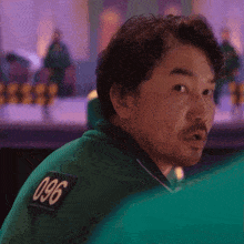 a man in a green shirt with the number 096 on the back