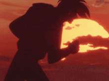 a silhouette of a person standing in front of a sun