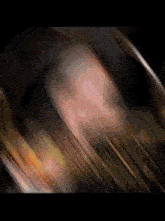 a blurry picture of a person 's face in a dark room with a blurred background