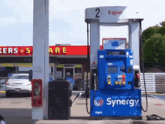 a blue and white gas pump that says synergy