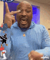 a man wearing a blue shirt with a snoopy sticker on it