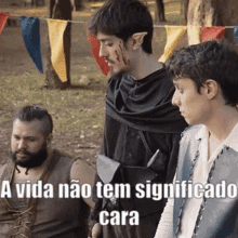 a group of men are standing next to each other in a park . one of the men has blood on his face .