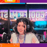 a woman wearing headphones is sitting in front of a sign that says " final "