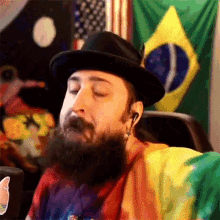 a man with a beard is wearing a hat and ear buds