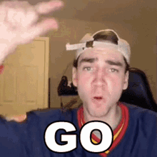 a man wearing a baseball cap and a sweater with the word go written on it