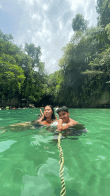 a boy and a girl are floating in a river