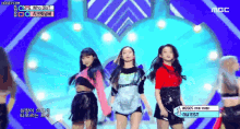 a group of girls are dancing on a stage with a sign that says nuest