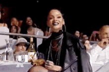 a woman in a leather jacket is sitting in a crowd of people .