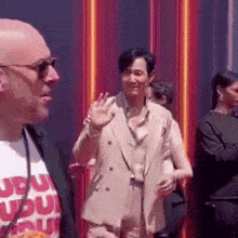 a man wearing sunglasses and a t-shirt that says ' ru ' on it is standing next to another man