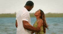 a man in a white shirt and a woman in a green dress are looking at each other