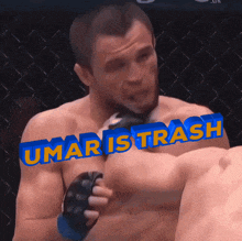 a man in a boxing ring with the words umar is trash written above him